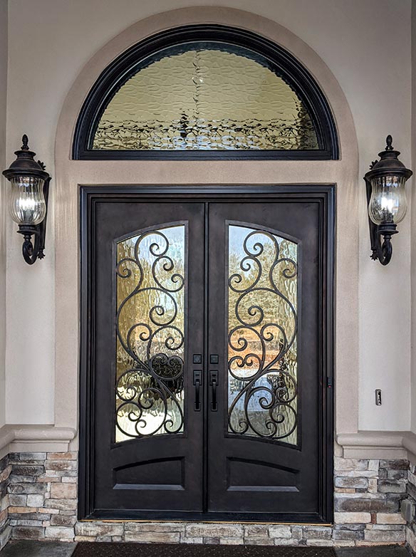 Italian style double door stock iron entry, large half-round transom, Flemish decorative glass, Patented Thermal Break, Hand-Rubbed Bronze finish