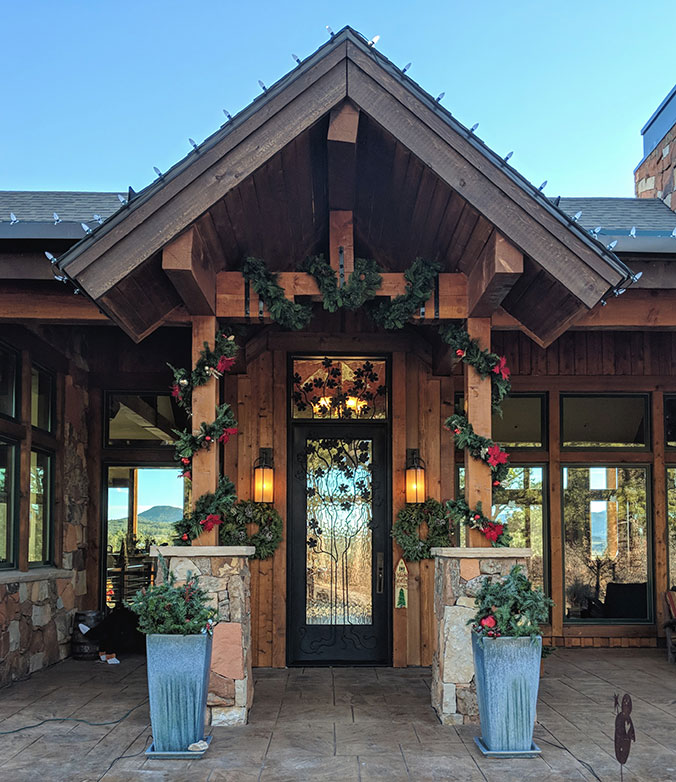 Colorado style ranch house with single custom iron door and transom, scrub oak tree iron grill, clear glass, Patented Thermal Break, Hand Rubbed Bronze finish