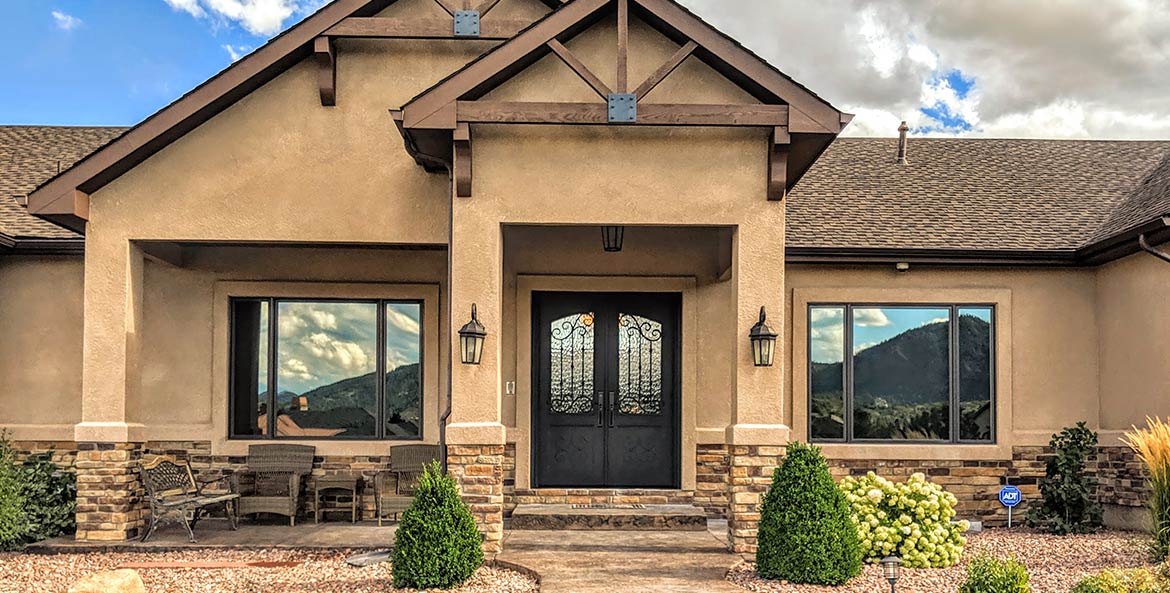 Close-up of custom double door iron entry, Spanish style, Flemish glass, Patented Thermal Break, Hand Rubbed Bronze finish