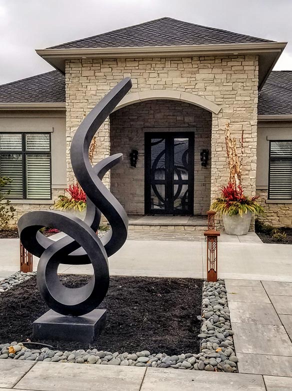 Site photo of home with custom contemporary designed double door iron entry, and large contemporary free-standing sculpture from Midwest Iron Doors matching door design, Clear glass, Patented Thermal Break, Black finish