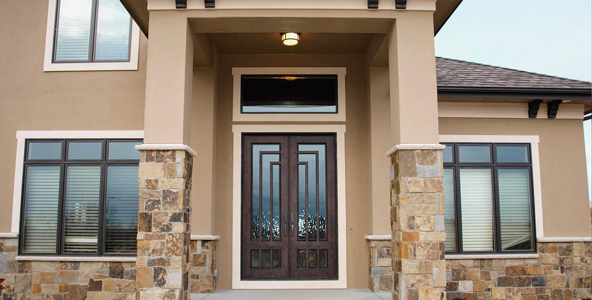 Site photo of home with custom Orion Series double door iron entry, with separate rectangular glass transom, Clear glass, Patented Thermal Break, Antique Bronze finish