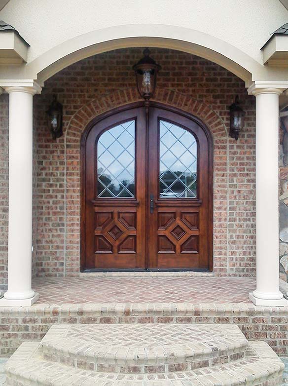 English Country style, custom double front entry doors, leaded glass, bolection molding, Gothic arched top, Mahogany