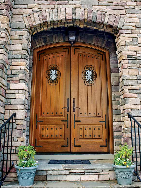 Arched top European style double front entry doors, vertical planked raised panels, iron clavos, iron straps & Iron grilled speakeasy, Tiffany Collection